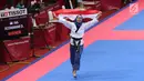 Atlet Taekwondo putri Indonesia, Defia Rosmaniar mengibarkan bendera Merah Putih saat merayakan kemenangan atas Salahshouri Marjan (Iran) pada Final Women Individual Poomsae di JCC, Jakarta, Minggu (19/8). (Liputan6.com/Helmi Fithriansyah)