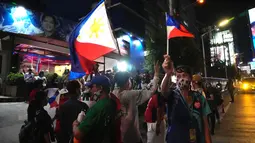 Pendukung tiba di markas besar Ferdinand "Bongbong" Marcos Jr di Mandaluyong, Filipina pada Senin malam (9/5/2022). Ferdinand Marcos Jr., putra mendiang Ferdinand Marcos, diktator Filipina yang terguling, jauh memimpin dalam penghitungan suara tidak resmi pemilu presiden hari Senin. (AP Photo/Aaron Favila)