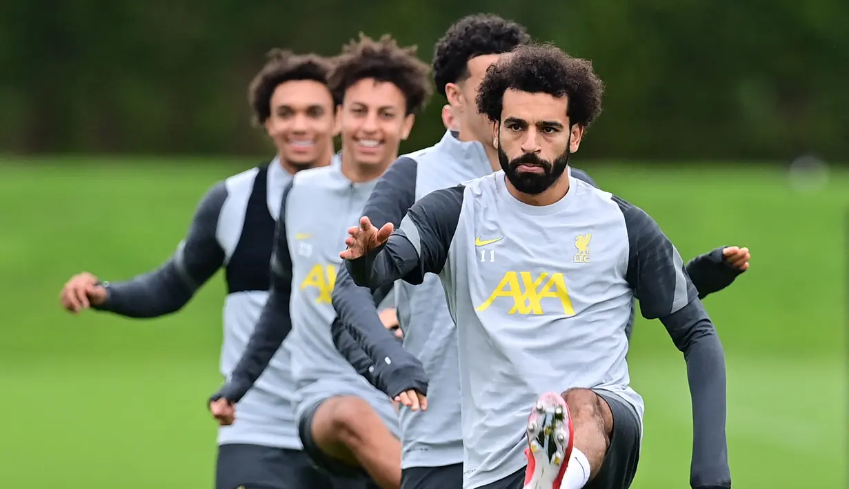 Penyerang Liverpool, Mohamed Salah (kanan) dan rekan satu timnya melakukan pemanasan selama sesi latihan di pusat pelatihan Axa di Kirkby, Liverpool, Inggris (14/9/2021). Liverpool akan bertanding melawan wakil Italia, AC Milan pada Grup B Liga Champions di Anfield. (AFP/Paul Ellis)