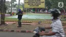 Pengendara melintas saat petugas memasang garis larangan melintas umum di Taman Merak, Limo, Depok, Senin (25/1/2021). Penutupan taman tersebut dilakukan dalam rangka Pemberlakuan Pembatasan Kegiatan Masyarakat (PPKM) untuk mengendalikan pandemi virus corona (Covid-19). (merdeka.com/Arie Basuki)