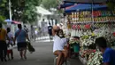 Penjual bunga menunggu pelanggan di dekat pemakaman di Manila, Filipina (28/10/2021). Pemerintah setempat akan menutup pemakaman nasional untuk Hari Semua Orang Kudus karena pandemi virus corona Covid-19. (AFP/Ted Aljibe)