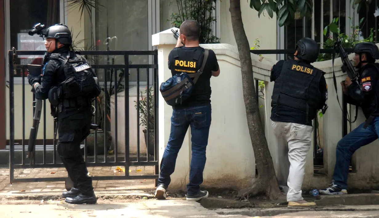 Tim Densus 88 mengepung seorang pria terduga teroris di dalam kantor Kelurahan Arjuna, Kota Bandung, Senin (27/2). Sebelum masuk ke kantor Kelurahan dan melakukan perlawanan, pelaku sempat meledakkan sebuah bom di Lapangan Pandawa. (Timor Matahari/AFP)