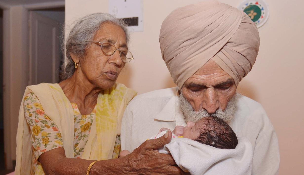 Daljinder Kaur (kiri) bersama sang suami Mohinder Singh Gill saat mengasuh anak mereka di Amritsar, India, (11/5).Setelah menikah selama 46 tahun, pasangan lansia ini akhirnya berhasil memiliki buah hati melalui program bayi tabung.( NARINDER NANU / AFP)