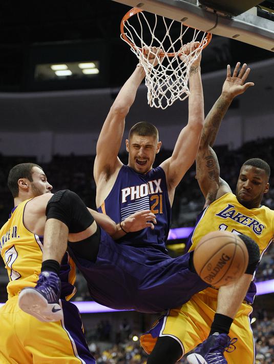 Aksi pemain Phoenix Suns, Alex Len, (tengah) saat melakukan dunk ditengah hadangan dua pemain Los Angeles Lakers pada laga NBA preseason basketball game di Anaheim, California (22/10/2016). (AP/Kelvin Kuo)