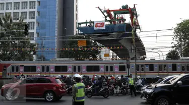 Kereta Commuter melintas di bawah proyek flyover Permata Hijau, Jakarta, Selasa (6/10/2015). Pelintasan kereta api di Permata Hijau yang menuju ke arah Patal Senayan akan ditutup karena pengerjaan struktur di atas pelintasan. (Liputan6.com/Yoppy Renato)