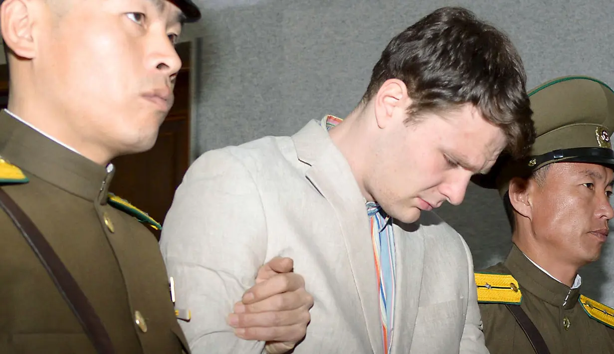 Mahasiswa University of Virginia, Otto Frederick Warmbier (tengah) saat digelandang oleh petugas keamanan Korea Utara di Pyongyang, (16/3). Ia didakwa karena sengaja mencuri pamflet berisi pesan propaganda pemerintah Korut di hotelnya. (REUTERS / Kyodo)