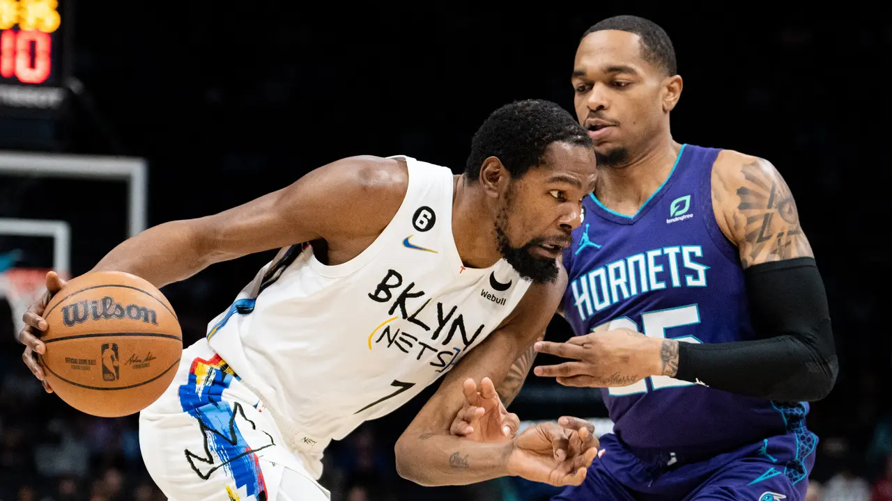Pemain Nets Kevin Durant melewati adangan pemain Hornets PJ Washington