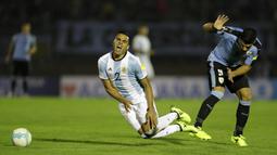 Pemain Argentina, Gabriel Mercado (kiri) menahan sakit berebut bola dengan pemain Uruguay, Luis Suarez pada laga kualifikasi Piala Dunia 2018 di Montevideo, Uruguay, (31/8/2017). Argentina bermain imbang 0-0. (AP/Natacha Pisarenko)