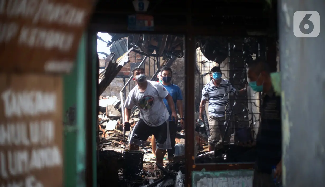 Warga berusaha memadamkan api yang membakar toko dan pemukiman di kawasan Manggarai, Jakarta, Selasa (7/7/2020). Hingga kini belum diketahui pengebab kebakaran. (Liputan6.com/Immanuel Antonius)