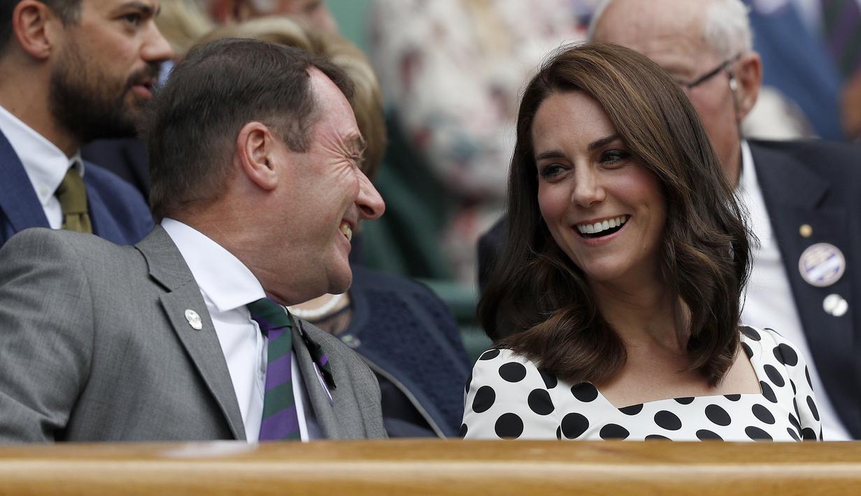 Kate Middleton berbincang dengan penonton lainnya saat menyaksikan pertandingan antara petenis asal Inggris, Andy Murray melawan petenis Rusia, Alexander Bublik pada babak pertama Wimbledon di London, Inggris (3/7). (AFP Photo/Adrian Dennis)