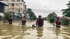 Penduduk setempat menyeberangi jalan yang banjir di Bago, sekitar 80 kilometer (50 mil) timur laut Yangon, Myanmar, Senin (9/10/2023). Banjir yang dipicu oleh hujan lebat di wilayah selatan Myanmar telah menyebabkan lebih dari 10.000 orang mengungsi dan mengganggu lalu lintas di jalur kereta api yang menghubungkan kota-kota terbesar di negara itu, kata para pejabat dan media pemerintah pada hari Senin. (AP Photo/Thein Zaw)