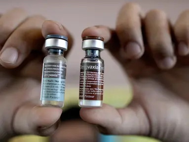 Perawat menunjukkan botol vaksin anti-dengue di Sekolah Dasar Parang di Marikina, sebelah barat Manila, Senin (4/4). Filipina telah melancarkan vaksin pertama di dunia untuk penyakit Demam Berdarah Dengue (DBD) itu kepada 1 juta pelajar. (NOEL CELIS/AFP)