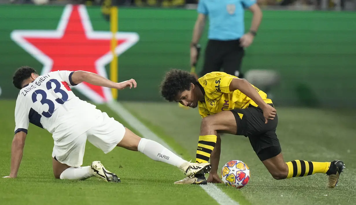 Striker Borussia Dortmund, Karim Adeyemi (kanan) berebut bola dengan gelandang PSG, Warren Zaire-Emery pada laga leg pertama semifinal Liga Champions 2023/2024 di Signal Iduna Park Stadium, Dortmund, Rabu (1/5/2024). (AP Photo/Matthias Schrader)