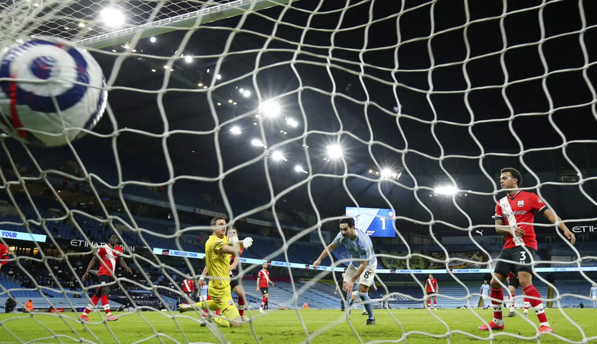 Pemain Manchester City, Ilkay Gundogan, mencetak gol ke gawang Southampton pada laga Liga Inggris di Stadion Etihad, Kamis (11/3/2021). City menang dengan skor 5-2. (Clive Brunskill/Pool via AP)