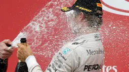 Wajah Rosberg terkena semprotan sampanye pada saat selebrasi kemenangannya pada seri ke-17 Formula One (F1) GP Jepang, Minggu (9/10). Rosberg bertahan berada di posisi terdepan dari awal hingga akhir balapan. (REUTERS/Toru Hanai) 