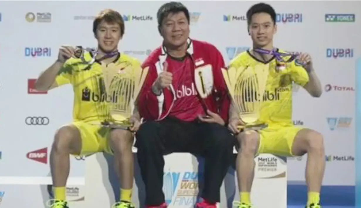 Pebulutangkis ganda putra Indonesia, Marcus Fernaldi Gideon dan Kevin Sanjaya Sukamuljo berpose menunjukkan medali bersama pelatih Aryono Miranat seusai bertanding pada final BWF Dubai Super Series Finals 2017, Minggu (17/12). (instagram/marcusfernaldig)