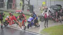 Pembalap dan kru berjalan menuju paddock saat hujan lebat sebelum Race 2 WSBK Mandalika 2021 di Pertamina Mandalika International Street Circuit, Lombok, Nusa Tenggara Barat, Minggu (21/11/2021). Balapan dilanjutkan pukul 15.30 WIB atau 16.30 Wita dan hanya digelar 12 lap. (BAY ISMOYO/AFP)