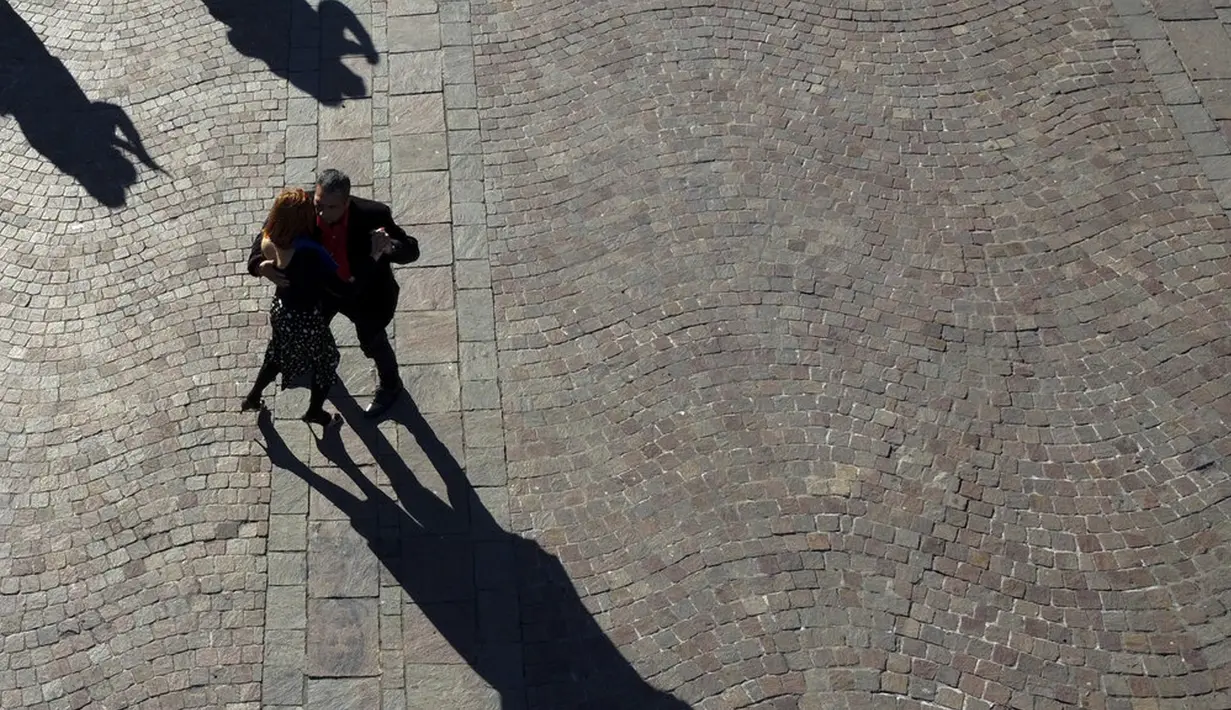 Sepasang suami istri menari tango saat demonstrasi menuntut diizinkan berlatih di ruang terbuka di tengah pembatasan karena melonjaknya kasus COVID-19 di Buenos Aires, Argentina, Sabtu (29/5/2021). Sejak pandemi, tango ditangguhkan untuk menghentikan infeksi COVID-19. (AP Photo/Natacha Pisarenko)