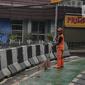 Petugas PPSU membersihkan sampah dekat beton pembatas di Jalan Senopati, Jakarta, Minggu (29/12/2019). Pascakejadian mobil tabrak Apotek Senopati, Suku Dinas Bina Marga memasangan beton pembatas untuk meminimalisir kejadian serupa terulang kembali. (Liputan6.com/Faizal Fanani)