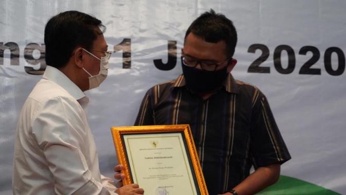 Menkes Terawan Agus Putranto memberikan penghargaan untuk 5 tenaga medis COVID-19 yang gugur di Jawa Tengah dalam kunjungan kerja di Semarang, Sabtu (11/7/2020). (Dok Biro Komunikasi dan Pelayanan Masyarakat Kementerian Kesehatan)