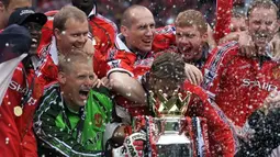 Selebrasi para pemain Manchester United dengan trofi juara Liga Inggris usai laga menghadapi Tottenham Hotspur di Old Trafford, Manchester (16/5/1999). Manchester United menjadi klub pertama yang mampu menyandingkan raihan trofi Liga Inggris dengan Piala FA dalam satu musim di Era Premier League. Momen itu terjadi pada musim 1998/1999 saat MU meraih treble winners, juara Liga Inggris, Piala FA dan Liga Champions. (AFP/PA/Owen Humphreys)