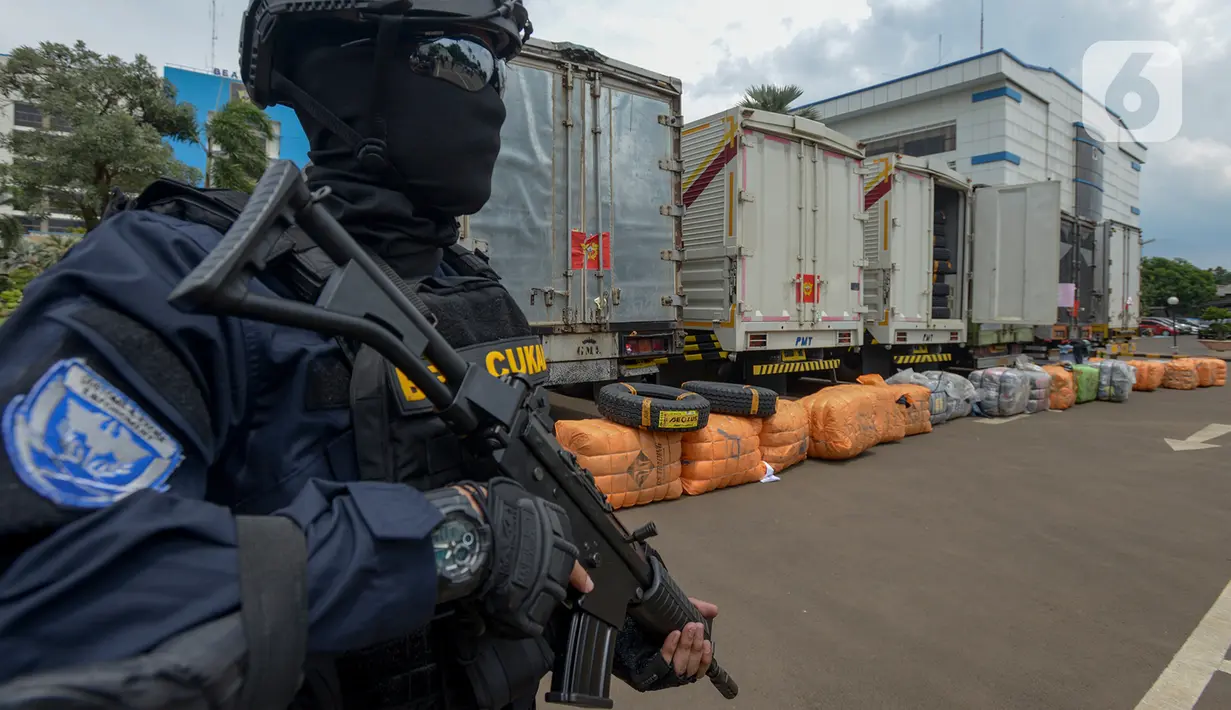 Petugas Direktorat Jenderal Bea dan Cukai (DJBC) Kementerian Keuangan membawa senjata saat menunjukkan barang bukti pakaian bekas selundupan di Jakarta, Rabu (11/3/2020). DJBC menyita 874 ballpress pakaian bekas yang diangkut delapan truk tronton. (merdeka.com/Imam Buhori)