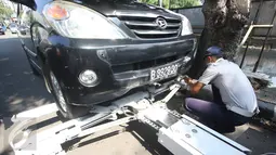 Petugas Dishub memasang alat derek ke kendaraan yang parkir liar di kawasan Pasar Baru, Jakarta, Kamis (7/1). Pemprov DKI berencana menaikan denda Rp 3 juta per hari terhadap kendaraan yang terjaring parkir liar. (Liputan6.com/Immanuel Antonius)