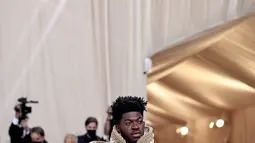 Penampilan Lil Nas X menghadiri The 2021 Met Gala Celebrating In America: A Lexicon Of Fashion di Metropolitan Museum of Art, New York City, Senin (13/9/2021). Lil Nas X yang hadir di Met Gala 2021 dengan penuh totalitas tampil menggunakan 3 busana sekaligus. (Dimitrios Kambouris/Getty Images/AFP)