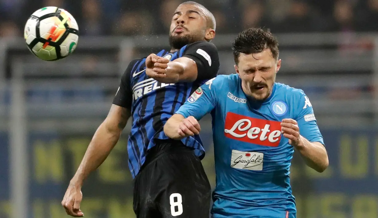 Pemain Inter Milan, Stevan Jovetic berebut bola dengan pemain Napoli, Mario Rui dalam lanjutan Serie A di Giuseppe Meazza, Senin (12/3). Inter Milan  dan Napoli harus puas berbagi angka dengan skor akhir 0-0. (AP/Luca Bruno)
