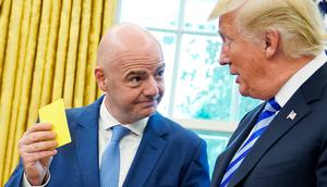 Presiden FIFA, Gianni Infantino menunjukkan kartu kuning kepada Presiden AS Donald Trump selama pertemuan di Oval Office Gedung Putih, Selasa (28/8). Presiden FIFA bertemu Trump untuk membahas kesiapan Piala Dunia 2026. (AFP/Mandel Ngan)