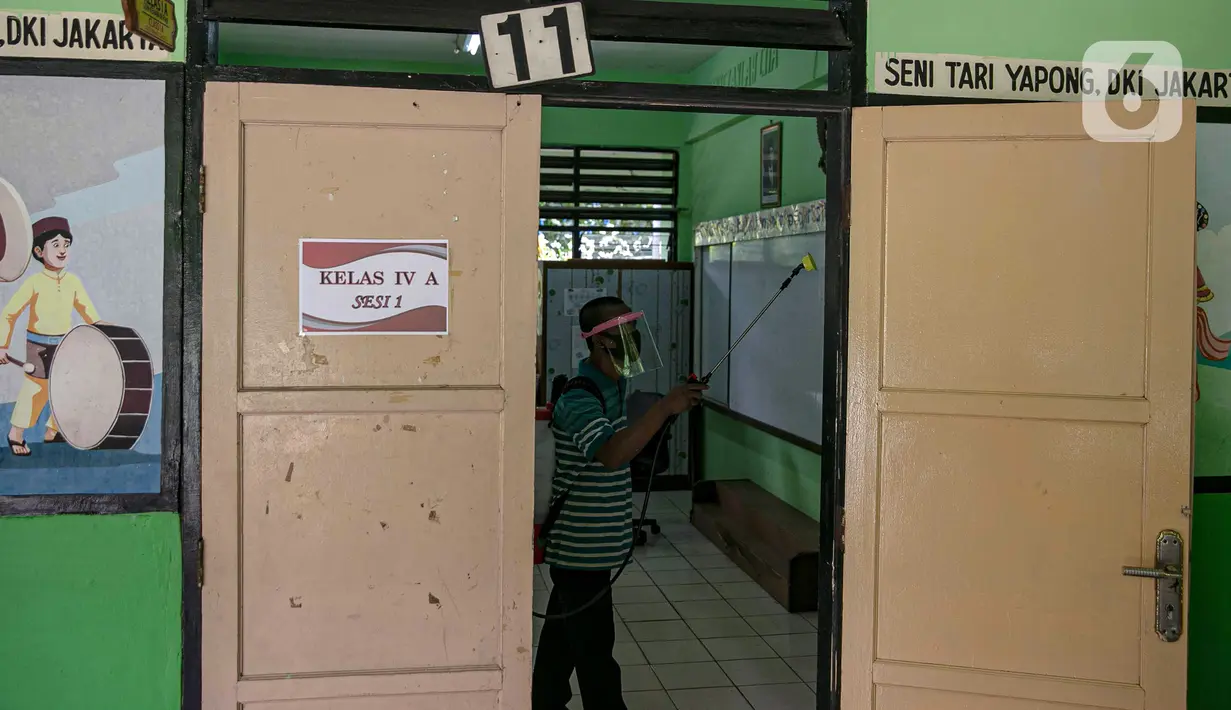 Seorang guru mendisinfeksi ruang kelas yang akan digunakan di SDN Kenari 08, Jakarta, Selasa (6/4/2021). Pemerintah Provinsi DKI Jakarta akan melakukan uji coba pembelajaran tatap muka terbatas di 100 sekolah mulai 7 April hingga 29 April 2021. (Liputan6.com/Faizal Fanani)