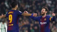 Pemain Barcelona, Lionel Messi dan rekan setimnya Luis Suarez merayakan gol ke gawang Real Betis pada pertandingan lanjutan La Liga di Stadion Benito Villamarin, Minggu (21/1). Barcelona menang telak 5-0 atas tuan rumah Real Betis. (AP/Miguel Morenatti)