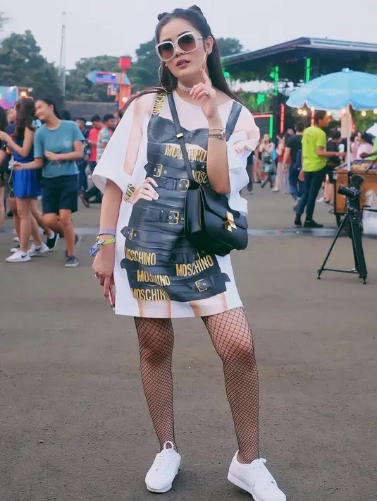 Seperti ini misalnya, Nindy memakai oversized shirt, Nindy memadukannya dengan stoking jaringjaring dan sneakers putih. Tatanan rambut yang unik dan kacamata hitamnya membuat tampilannya makin keren. (Instagram/nindyparasadyharsono)