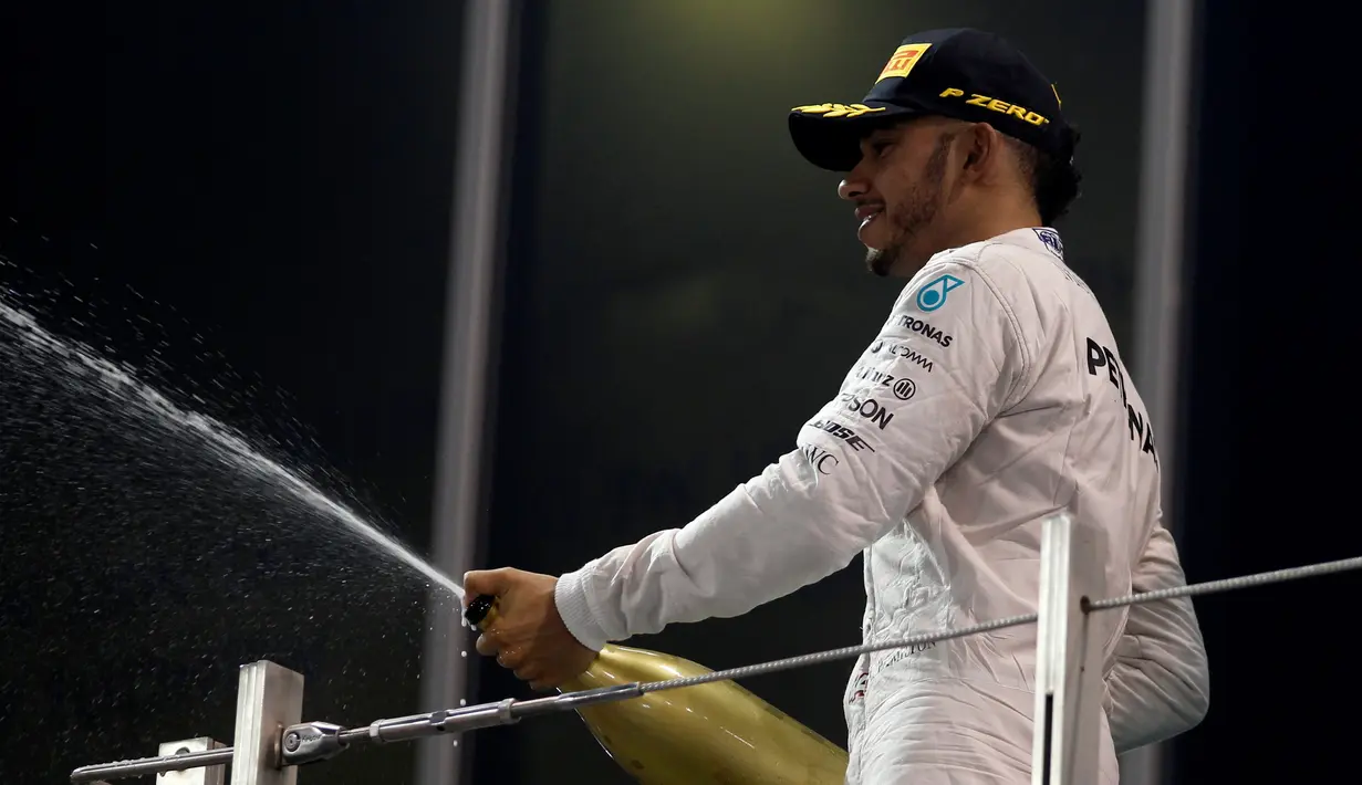 Pembalap Mercedes asal Inggris, Lewis Hamilton menyemprotkan sampanye saat merayakan kemenangan Rosberg sebagai juara Formula 1 2016 di sirkuit Yas Marina di Abu Dhabi, Uni Emirat Arab, (27/11). (REUTERS/Hamad I Mohammed)