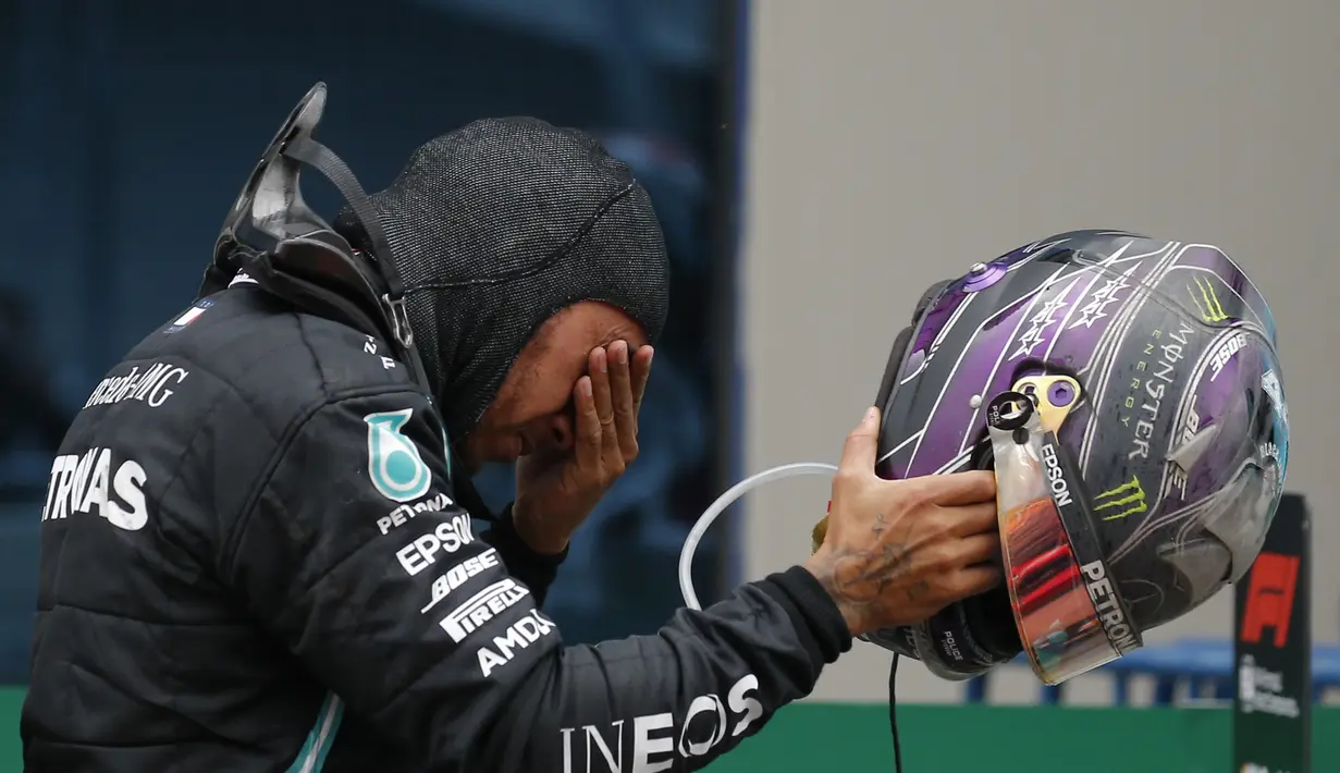 Pembalap Mercedes Lewis Hamilton dari Inggris menangis setelah memenangkan Grand Prix Formula Satu Turki di arena pacuan kuda Istanbul Park di Istanbul, Minggu (15/11/2020). (AP Photo/Kenan Asyali, Pool)