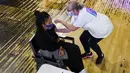 Seseorang menerima suntikan vaksin Pfizer di pusat vaksinasi Covid pop-up, yang didirikan di klub malam Heaven di London, Minggu (8/8/2021). Heaven menjadi klub malam pertama di Inggris yang diubah sebagai pop-up pusat vaksinasi untuk mencoba mengajak kaum muda agar mau divaksin (AP/Alberto Pezzali)