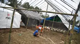 Pengungsi Gunung Agung membangun tenda untuk keluarganya di Posko Pengungsi Rendang, Bali, Sabtu (2/12). Bertambahnya jumlah pengungsi membuat mereka harus mendirikan tenda untuk tempat tinggal sementara. (Liputan6.com/Immanuel Antonius)