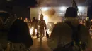 Para penari melakukan ritual kuno di sekitar api unggun mengusir roh-roh jahat di jalan-jalan Batanovci, Bulgaria, Kamis (13/1/2022). Untuk dua tahun ini festival topeng memiliki arti ekstra: orang-orang berharap itu akan membawa kelegaan dari kesengsaraan pandemi corona. (AP/Valentina Petrova)