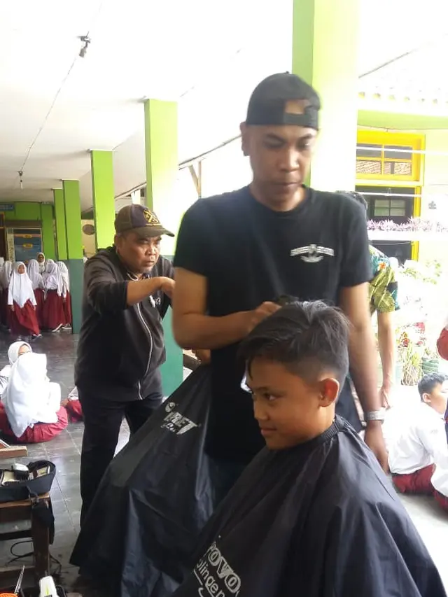 Para siswa SDN 1 Bayongbong, Garut nampak asik saat pelaksanaan cukur rambut gratis saat Hari Anak Sedunia