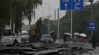 Otoritas meteorologi di Beijing mempertahankan siaga merah untuk hujan badai pada Senin pagi, memperingatkan bahwa sungai berukuran kecil dan sedang dapat mengalami banjir bandang dan tanah longsor. (AP Photo/Andy Wong)