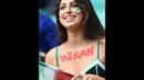 Fans cantik Iran mengecat dadanya dengan tulisan IRAN saat menyaksikan pertandingan Iran kontra Bosnia-Hercegovina the Fonte Nova Aren pada 25 Juni 2014 (AFP PHOTO/JAVIER SORIANO)