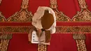 Seorang anak yatim Muslim mengenakan masker bertadarus sambil menjaga jarak sosial di dalam pusat panti asuhan selama bulan suci Ramadan di Srinagar (11/5/2020). (AFP/Tauseff Mustafa)