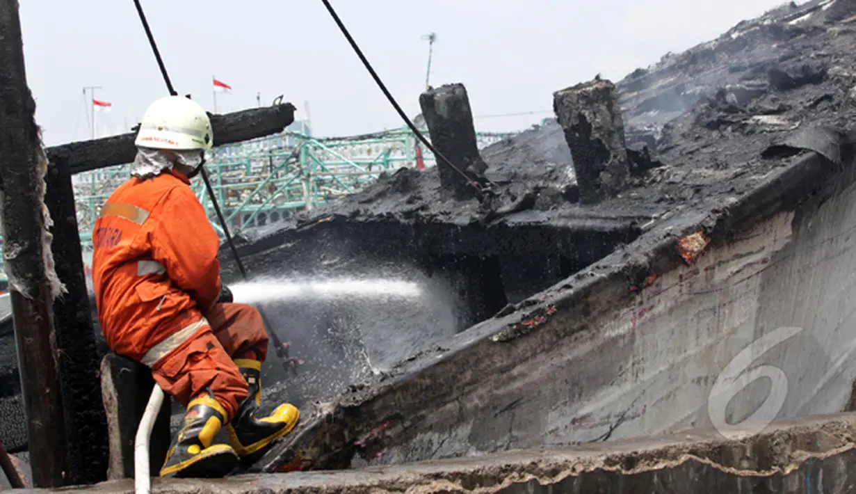 Petugas pemadam kebakaran menyemprotkan air ke kapal nelayan yang terbakar di Pelabuhan Muara Angke, Jakarta, Jumat (27/2/2015). Diduga kebakaran disebabkan korsleting listrik. Kerugian ditaksir mencapai ratusan juta. (Liputan6.com/Johan Tallo)