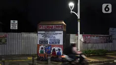 Warga melintas di dekat instalasi peringatan bahaya COVID-19 di kawasan Kemang, Jakarta, Selasa (15/9/2020). Guna mengurangi pola penyebaran COVID-19, Pemda DKI Jakarta kembali menerapkan PSBB dengan membatasi aktivitas warga, perdagangan maupun perkantoran. (Liputan6.com/Helmi Fithriansyah)