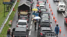 Sejumlah pedagang asongan menawarkan dagangan kepada pengendara di jalan tol Jagorawi yang sedang menanti waktu buka tutup jalur menuju kawasan wisata puncak, Bogor, Jawa Barat, Sabtu (31/10/2020). (Liputan6.com/Helmi Fithriansyah)