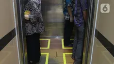 Sejumlah orang menaiki lift yang telah dipasangi garis batas dan saling membelakangi di PMI DKI Jakarta, Jumat (20/3/2020). PMI DKI Jakarta memberlakukan disiplin saling menjaga jarak atau social distancing sebagai langkah untuk mengantisipasi penyebaran COVID-19. (Liputan6.com/Herman Zakharia)