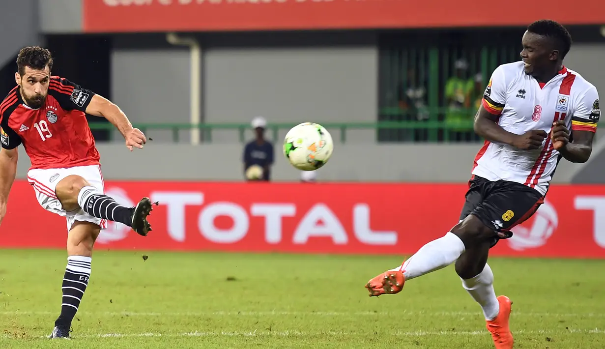 Pemain Mesir, Abdallah Kata (kiri) menendang bola melewati pemain tengah Uganda Khalid Aucho saat Piala Afrika 2017 di Port-Gentil pada 21 Januari 2017. (AFP PHOTO / Justin Tallis)