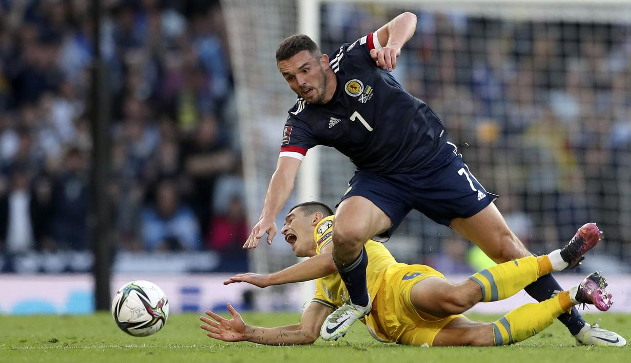 Pemain Skotlandia John McGinn (atas) berduel memperebutkan bola dengan pemain Ukraina Taras Stepanenko pada pertandingan play-off kualifikasi Piala Dunia 2022 di Hampden Park Stadium, Glasgow, Skotlandia, 1 Juni 2022. Ukraina menang 3-1. (AP Photo/Scott Heppell)