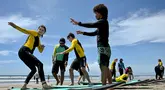 Masyarakat belajar selancar di Pantai Kuta, Bali, 8 Desember 2023. (SONNY TUMBELAKA/AFP)