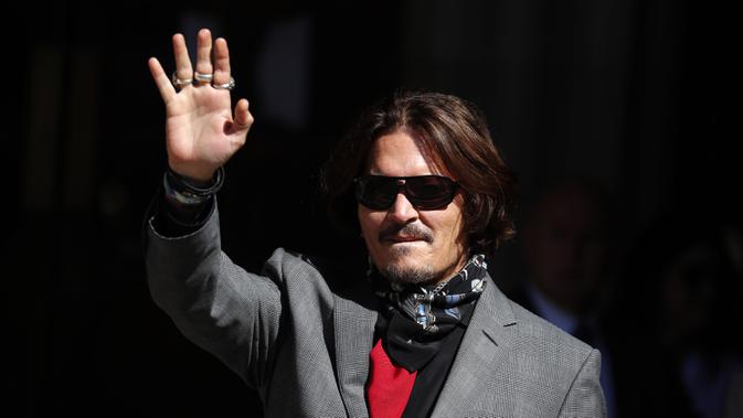 Aktor Johnny Depp memakai kacamata hitam dan syal saat menghadiri sidang pencemaran nama baik di Pengadilan Tinggi, London, Inggris, Selasa (21/7/2020). Johnny Depp menggugat tabloid The Sun atas artikel yang menyebut dirinya telah melakukan kekerasan terhadap sang istri. (AP Photo/Frank Augstein)